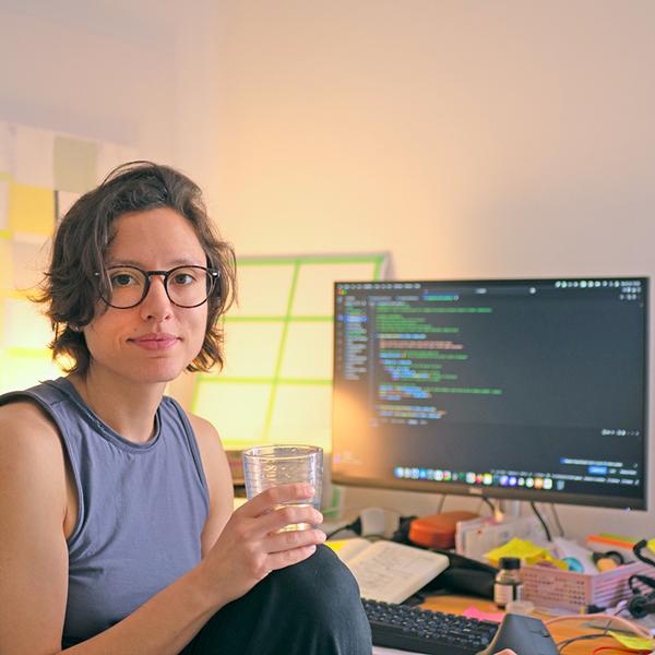 Micaela Rava, fundadora de Linaweb, sentada en su escritorio frente a un ordenador con código en pantalla