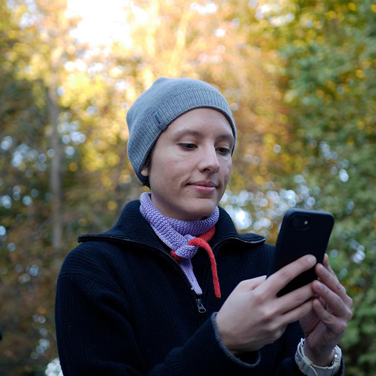 Mujer emprendedora usando su portátil en casa, rodeada de un ambiente de cocina y trabajo.
